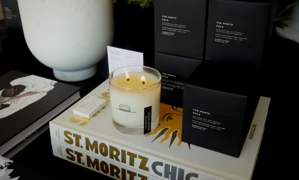 Lit candle and books on a stylish black table setting