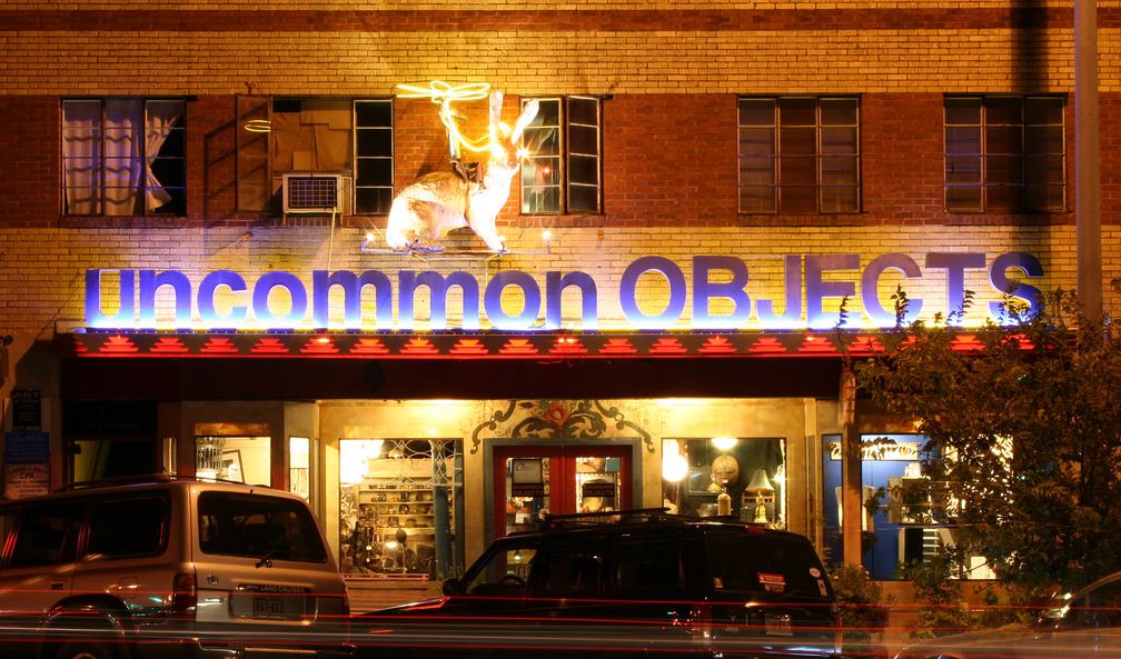 Vintage store Uncommon Objects exterior at night with neon sign and glowing rabbit figure