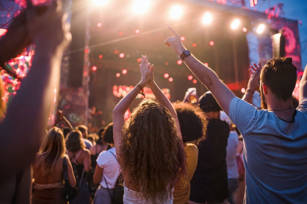 Audience enjoying a lively outdoor concert under bright stage lights